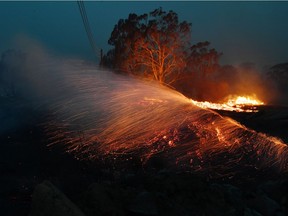 Flying embers are seen from a burnt out area on Friday, Jan. 23, 2020, in Moruya, Australia.