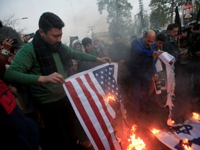 Pakistani Shi'ite Muslim burns U.S .and Israeli flags to condemn the death of Iranian Major General Qassem Soleimani in Lahore, Pakistan.