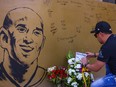 A fan places flowers to mourn former Los Angeles Lakers basketball player Kobe Bryant following his death overnight in the US, near the "House of Kobe" gym built in honour of his 2016 visit to the Philippines, in Manila on January 27, 2020.