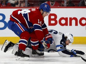 Canadiens centre Nick Suzuki lays Winnipeg Jets right wing Blake Wheeler down during NHL action in Montreal, on Monday, January 6, 2020.