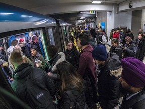 Montrealers politely line up to use the Orange Line at the Berri métro station in this file photo.