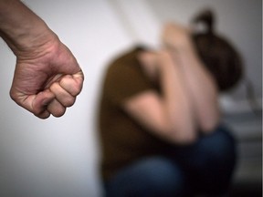 This illustration photograph taken on September 2, 2019, shows a woman hiding her face in front of a man's fist in Nantes, replicating a scene of domestic violence. Six women have recently been killed by their intimate partners in Quebec.