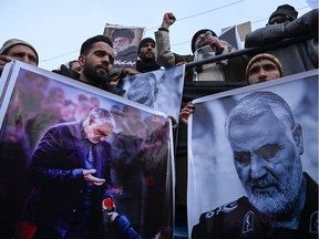 Protesters shout slogans against the United States and Israel as they hold posters with the image of top Iranian commander Qasem Soleimani, who was killed in a U.S. airstrike in Iraq, and Iranian President Hassan Rouhani during a demonstration in the Kashmiri town of Magam on January 3, 2020.