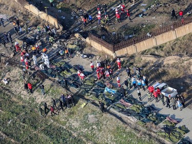 People and rescue teams are pictured amid bodies and debris after a Ukrainian plane carrying 176 passengers crashed near Imam Khomeini airport in the Iranian capital Tehran early in the morning on January 8, 2020, killing everyone on board.