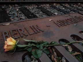 A rose is placed on a plaque detailing the transport dates and destinations of Jews sent from Berlin to various concentration camps between 1942 and 1944, at the Platform 17 memorial, next to the Gruenewald S-Bahn station in Berlin.