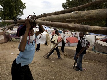 A boy carries branches to build a tent within a tent city on the grounds of the Petionville Golf Club in Port-au-Prince, Haiti, on January 26, 2010.