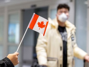 A traveller wears a mask at Pearson airport arrivals, shortly after Toronto Public Health received notification of Canada's first presumptive confirmed case of novel coronavirus, in Toronto, Ontario, Canada January 26, 2020. REUTERS/Carlos Osorio