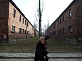 Jona Laks, survivor of Nazi Dr. Josef Mengele's experiments and her granddaughter, Lee Aldar, walk as they visit the Auschwitz death camp in Oswiecim, Poland, on Sunday, Jan. 26, 2020.