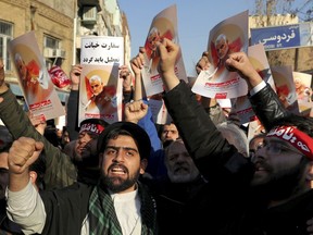 Hardline protesters chant slogans while holding up posters of Gen. Qassem Soleimani in front of the British Embassy in Tehran, Iran, on Sunday, Jan. 12, 2020.