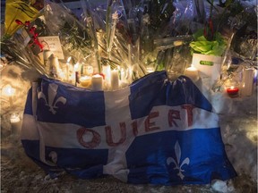 A Quebec flag bearing a message of openness is held at a vigil for the six victims of the Quebec City mosque shooting on Jan. 30, 2017.
