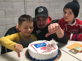 Eight-year-old Jacob Bertrand (left) poses with his father Mathieu Bertrand and a friend in a handout photo. His family ordered a Toronto Maple Leafs cake for Jacob's birthday and got a cake with a Maple Leaf Foods logo instead.
