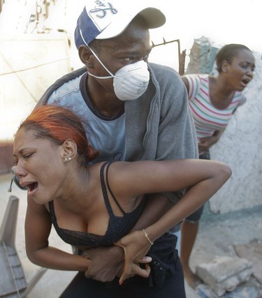 Survivors weep after two bodies are found in the remnants of a building in Port-au-Prince, Haiti, on January 15, 2010.