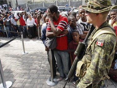 Canadian military secure the gate as people trying to leave the country line up at the Canadian embassy in Port-au-Prince, Haiti, on January 17, 2010.
