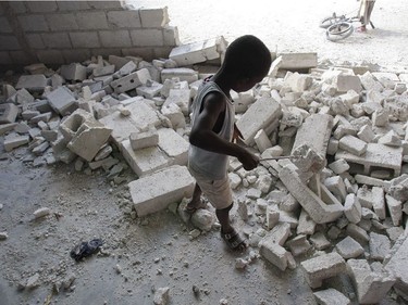 A boy plays amid the remains of a wall that fell and injured a child during last week's earthquake at La Maison Espoir d'enfants orphanage in Port-au-Prince, Haiti, on January 19, 2010.