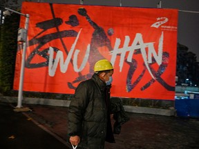 A man wearing a protective facemask walks along a street in Wuhan on Sunday, Jan. 26, 2020, a city at the epicentre of the viral outbreak.