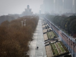 Two residents walk in an empty Jiangtan park on Jan. 27, 2020 in Wuhan, China. The city of 11 million people remains on lockdown for a fourth day.