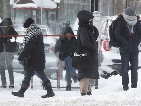 Commuters wait in the cold for a bus on Sherbrooke St. near La Fontaine Park.