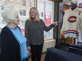 Jean Béliveau's wife Élise and daughter Hélène look at the Canadiens legend's 1962-63 wool game jersey at the Bell Centre in Montreal on Tuesday, Feb. 4, 2020. The jersey is among a larger selection of Béliveau memorabilia being auctioned by Classic Auctions on behalf of the family.
