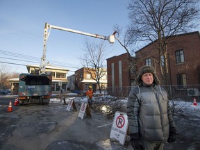 Resident Stephane Licari, concerned about development plans in Pointe-Claire Village, stands by as crews cut down a tree near the old Pioneer bar property.
