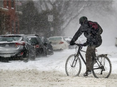 A cyclist braves a snowy passage on Sherbrooke St. W. Friday morning.