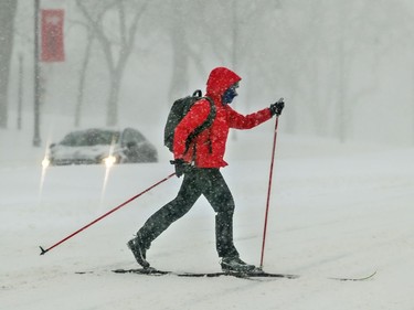 A cross-country skier crosses Park Ave. during a snow storm in Montreal on Friday, Feb. 7, 2020.