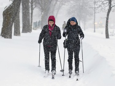 Dominique Chouinard, left, and Marie-Dominique Emond ski along the sidewalk on Park Ave. during a snow storm in Montreal on Friday, Feb. 7, 2020.