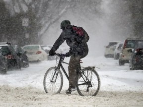 A cyclist rides on Sherbrooke St. W. during snow storm in Montreal Friday February 7, 2020.
