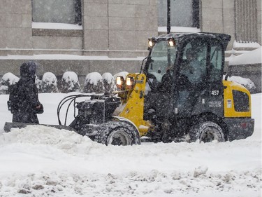 A sidewalk plow slows to let a pedestrian pass on Sherbrooke St. W. Friday morning.