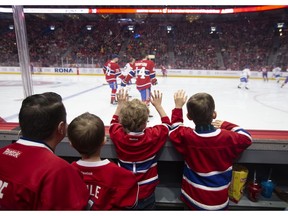 David St-Germain with his two sons — 2-year-old Emile and 4-year-old Liam — and 4-year-old Louis Samson watch as the Canadiens take part in their annual skills competition at the Bell Centre in Montreal on Sunday, Feb. 9, 2020.