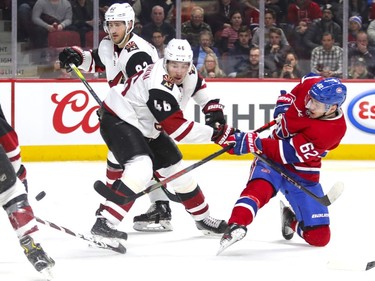 Montreal Canadiens Artturi Lehkonen takes a shot from one knee against Arizona Coyotes Jordan Oesterle, left, and Ilya Lyubushkin during third period of National Hockey League game in Montreal Monday February 10, 2020.