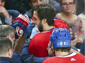 The Canadiens' Phillip Danault is helped to the dressing room after being hit in the mouth with a shot from teammate Tomas Tatar during NHL game against the Arizona Coyotes at the Bell Centre in Montreal on Feb. 10, 2020.