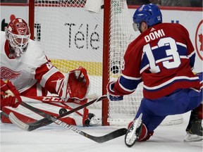 Montreal Canadiens' Max Domi falls as he shoots on Detroit Red Wings goaltender Jonathan Bernier in Montreal on Dec. 14, 2019.