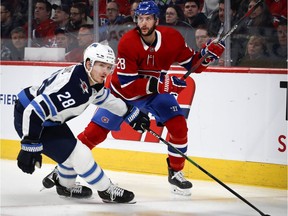 Winnipeg Jets centre Jack Roslovic tries to slow Montreal Canadiens defenceman Marco Scandella in Montreal, on Jan. 6, 2020.