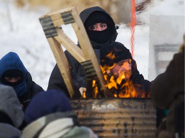 Protesters block the CN railway tracks near the St-Lambert train station south of Montreal early Friday, Feb. 21, 2020.