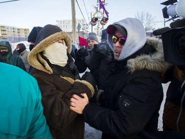 Eric St. Laurent (right) yells at protesters blocking the CN railway tracks near the St-Lambert train station south of Montreal early Friday, Feb. 21, 2020.