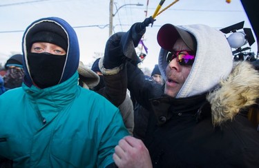 Eric St. Laurent (right) yells at protesters blocking the CN railway tracks near the St-Lambert train station south of Montreal early Friday, Feb. 21, 2020.