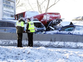 A pickup truck sits on top of a car at the scene of a multi-car accident on Highway 15 West in Laprairie on Wednesday, Feb. 19, 2020.