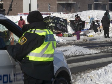 Police keep watch on protesters at blockade on the train tracks in Longueuil near Oak Ave. and St Georges St.