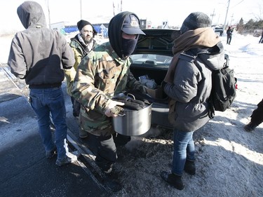 Protesters get pot of soup from passerby at blockade on the train tracks in Longueuil St-Georges St. on Thursday February 20, 2020.