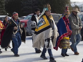 Wet'suwet'en hereditary chiefs walk prior to taking part in a ceremony at the Kahnawake Longhous on Saturday, Feb. 22, 2020. He and other hereditary chiefs were there to thank the Mohawk protesters for their support in their continuing battle to block a pipeline on their ancestral lands in British Columbia.