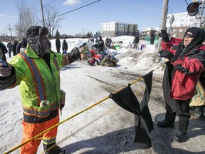 A citizen, right, argues with a member inside the blockade on the train tracks in Longueuil near Oak av. and St Georges st. on Friday February 21, 2020. The blockade is part of the protest is in support to Wet'suwet'en.