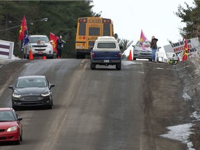 Two women monitor a checkpoint on Highway 344 in Oka on Tuesday. Traffic was limited to one lane through the checkpoint, but the road was not closed.