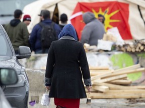 A woman dressed in traditional clothes arrives at the barricade as the Mohawks of Kahnawake continue their blockade of the CP Rail lines south of Montreal on Tuesday, Feb. 25, 2020.