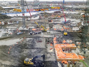 Five cranes, cement mixers, bulldozers and workers in hard hats busied themselves on the Royalmount mega-mall project on Tuesday. The project is on schedule and on budget, developer Carbonleo says.