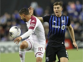 Deportivo Saprissa's Marvin Angulo keeps ball away from Impact defender Luis Binks during first-half  CONCACAF Champions League action at Olympic Stadium Wednesday night.