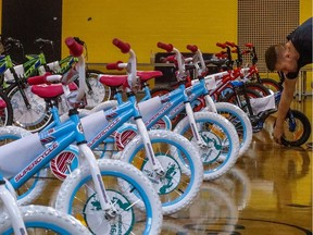 A Sun Youth staff member helps set up 83 new bicycles for deserving kids in 2017.
