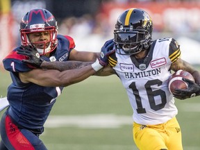 Alouettes' Ciante Evans pushes Tiger-Cats Brandon Banks out of bounds game last season. Evans re-signed with teh team on Tuesday, the first day of CFL free agency.