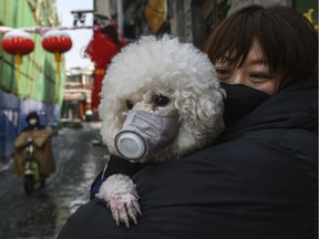 A woman takes precautions for herself and her pet in Beijing, China.