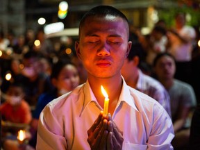 Thai mourners attend a candlelight vigil for the victims of the Terminal 21 Mall shooting on Sunday, Feb. 9, 2020, in KORAT, Thailand.