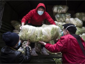 Employees wear protective masks while carrying vegetables from trucks at a hospital Monday, Feb. 10 in Wuhan, China. “It would be a miracle if the virus didn’t start spreading in Canada,” says a Montrealer who visited her family in China but cut short her trip after the coronavirus outbreak escalated.